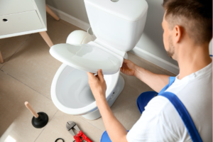Professional Plumber Installing Toilet