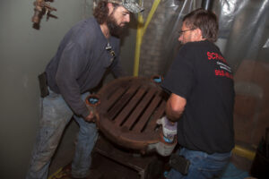 2 Plumbers Removing Heavy Iron Component of Old Gravity Furnace From Home
