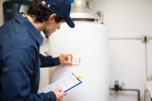 Plumber Holding Clipboard and Inspecting Newly Installed Water Heater