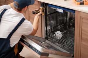 Plumber installing a built-in dishwasher