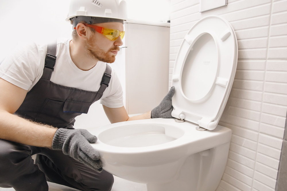 Professional plumber repairing a toilet