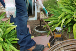 Professional Plumber Using a Sewer Snake to Clean a Sewer Line Blockage